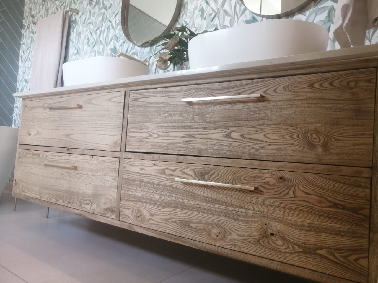 Close view of a double vanity in wire-brushed ash with long slim handles