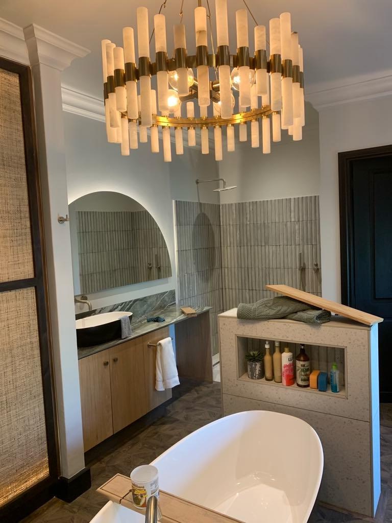 Main bathroom with an oak vanity and a built-in storage divider behind a freestanding bath